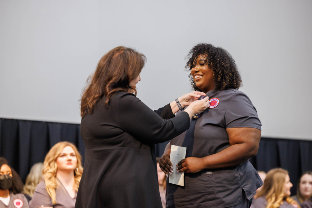 Sharolyn Slater getting pinned by the dean during Pinning ceremony.